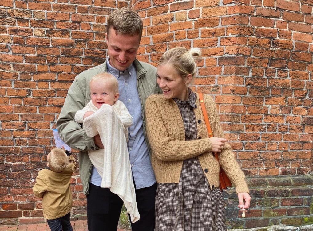 Mette Wendelboe Okkels med mand og børn foran kirke efter barnedåb